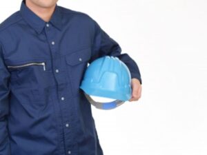 ヘルメットを持つ作業服の男性